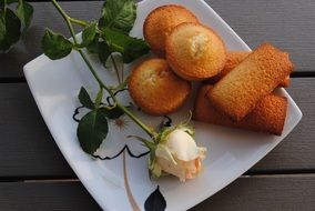 Cakes and rose on white plate