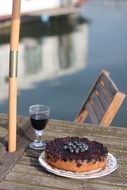 cupcake with blueberries and a glass of red wine in a cafe on the coast