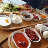 olive oil, milk, salad, tomato, coffee, bread on a buffet