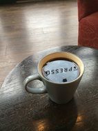 espresso in a small cup on the wooden surface