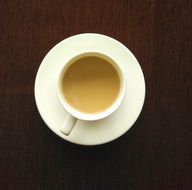 Coffee in white cup on Brown table