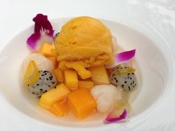 Different varities of fruits and the orange ice cream