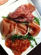 slicing salami on a plate