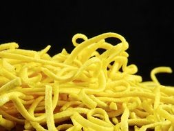 egg noodles on the black background