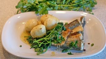 fish with potatoes and spinach on a plate