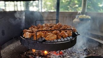 cooking meat on an open fire in summer