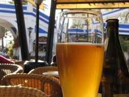 a glass of light beer on a table in a cafe
