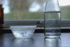 Water in a glass bottle and glass bowl