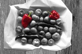 black and white photo of tomato, chili pepper and red pepper in a basket