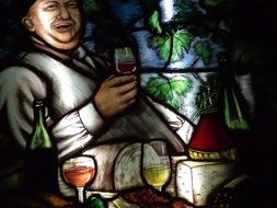 stained glass image of a man in a cellar with wine