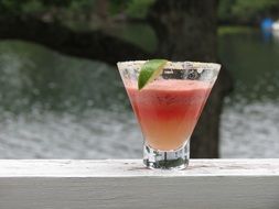 cocktail in a glass with a slice of lime