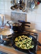 zucchini cooking in pan on Gas Stove in Kitchen