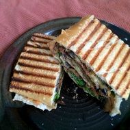 grilled sandwich on a black plate