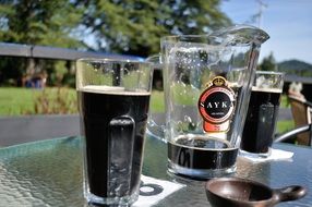 dark beer in glass glasses in the sun