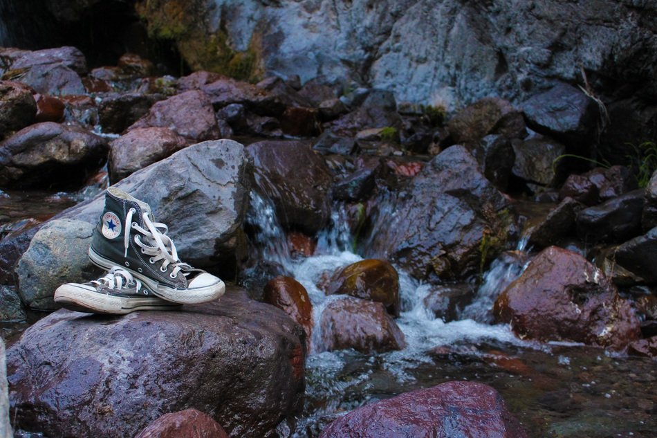 Converse Shoes on Rocks near waterfall