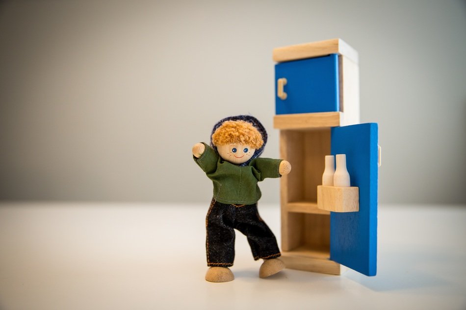 a toy man stands near the refrigerator