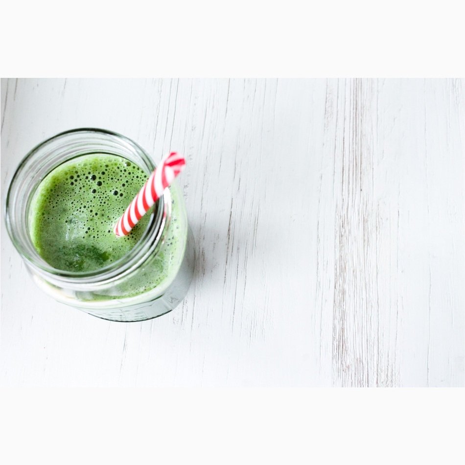 Green foamy Drink in glass, top view