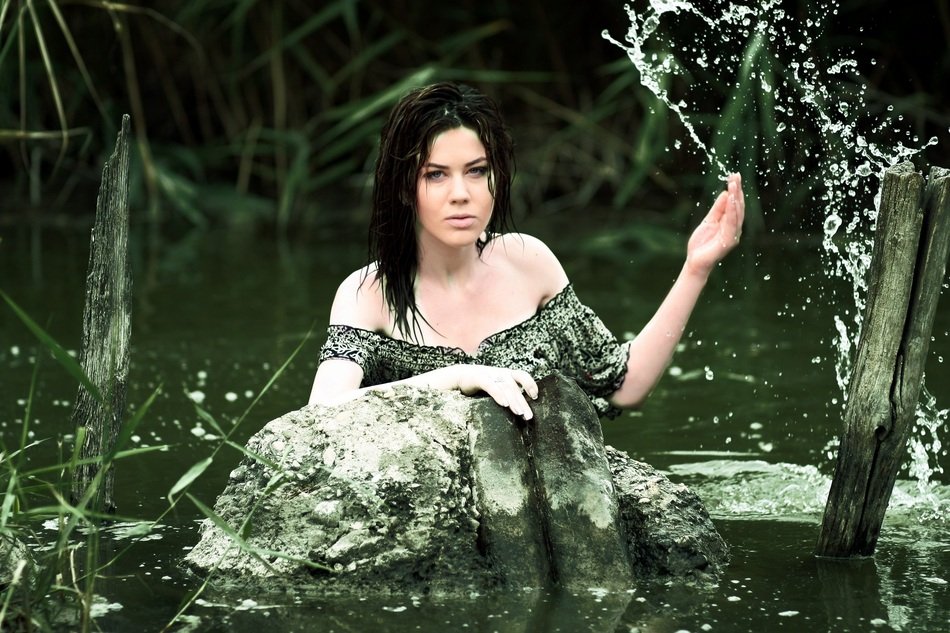 young woman splashing around in the pond