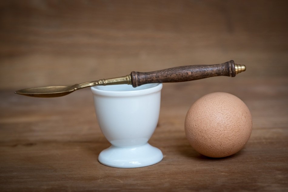 brown egg with egg cup and spoon