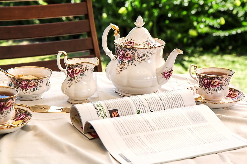 porcelain tea set on the table near the magazine in the garden