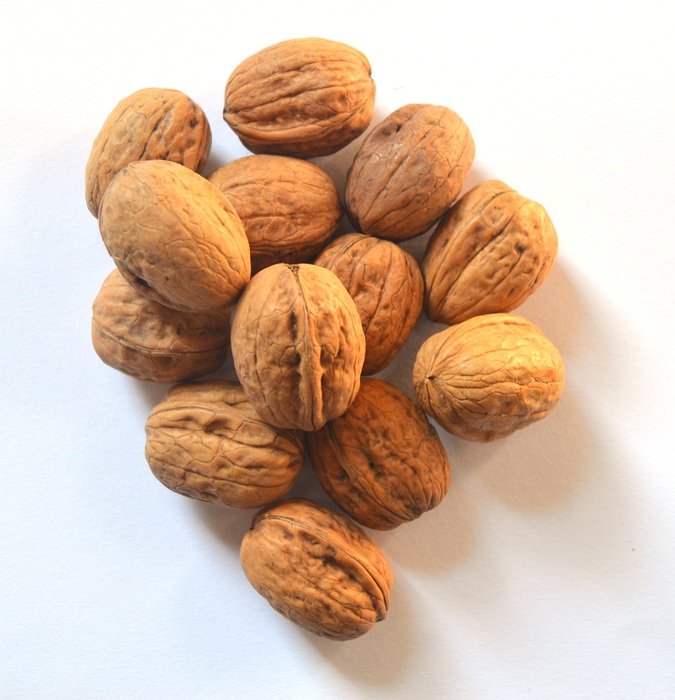 dried wallnuts on white surface