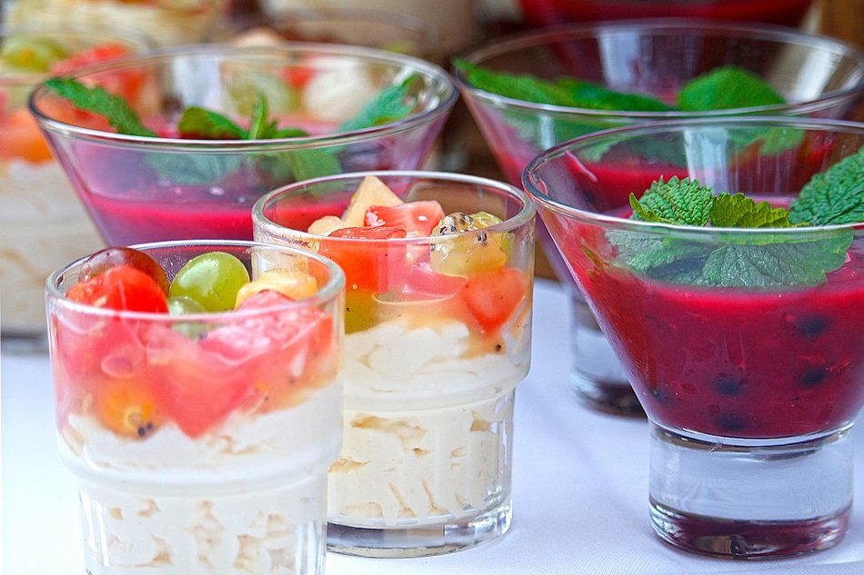 fruit desserts with berries and mint in glasses close-up