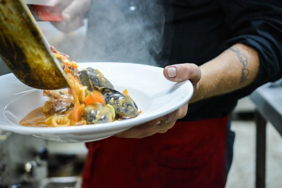 man pouring seafood to plate