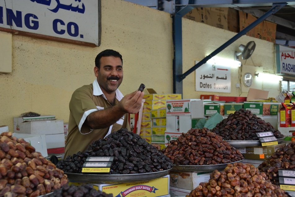 smiling man sells Fruits on Market, uae, Dubai