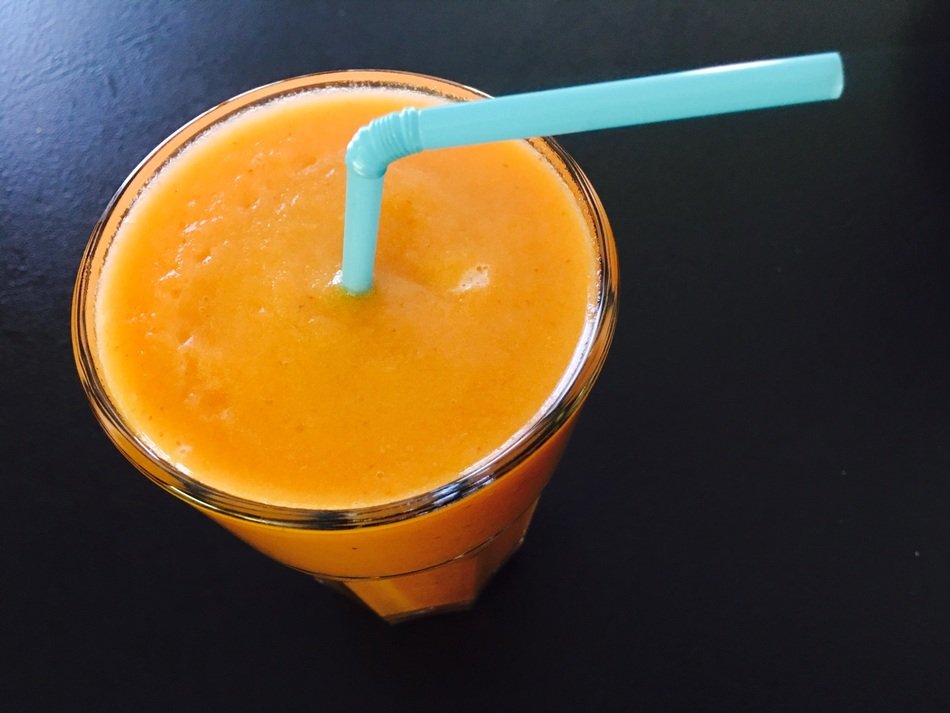 Orange Smoothie in glass, dsrk background