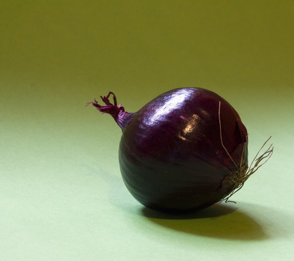 Purple onion on a green surface