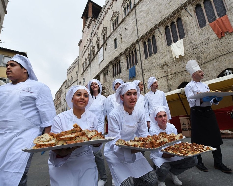 confectioners posing with pastry on street in city