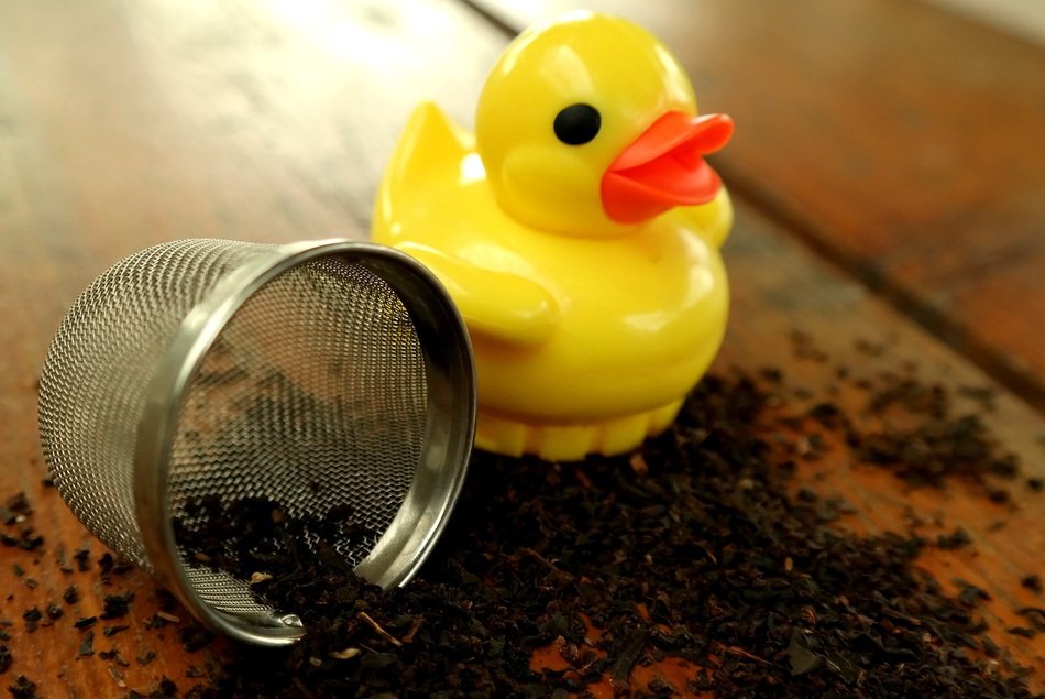 ceramic duck near tea leaves