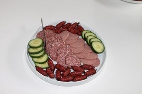 sausage sliced with cucumbers on a plate