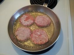 four cutlets are fried in a pan
