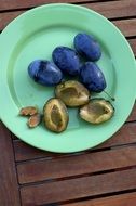 ripe plums on a blue plate