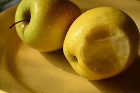 yellow bitten apple on a plate