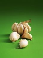 Garlic cloves on green surface