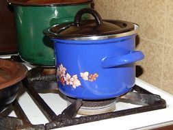 old colorful metal Pots on gas stove