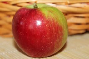 ripe apple near a wicker basket