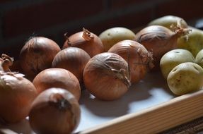 raw Onions and Potatoes on shelf