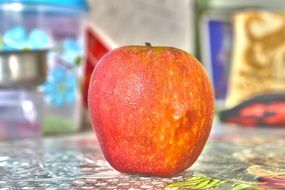 big red sweet ripe apple on a glass surface close up