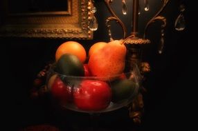 fruits in a bowl on a table in the dark
