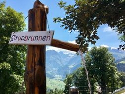 Syrupbrunnen sign on wooden water fountain, switzerland, glarus, braunwald