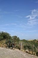 two bicycles stands at fence on sand Dune