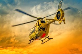 flying rescue helicopter on the yellow sky