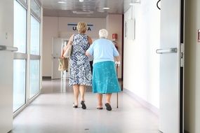 Elderly woman walking in a hospital corridor