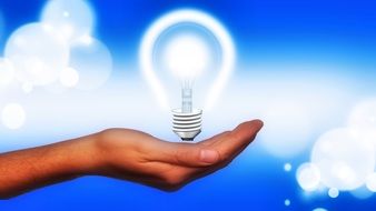 electric lamp on hand on a blue background