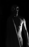 dark photo of a naked masked man