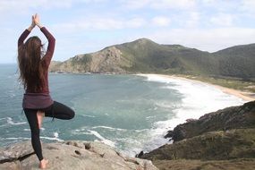 girl in yoga pose on the background of the picturesque landscape