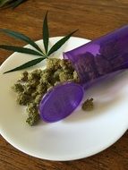 marijuana on a white plate in a purple tray
